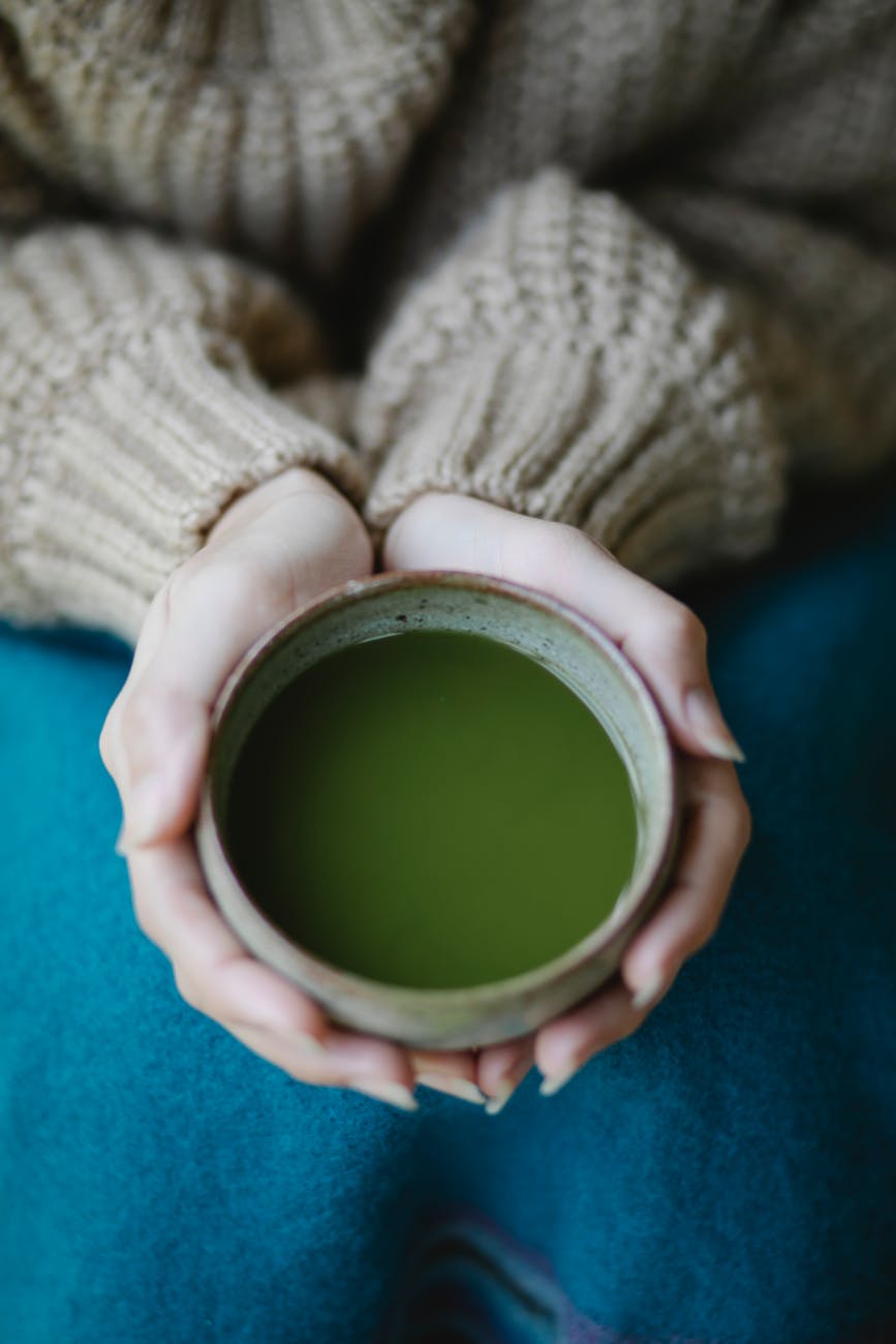 crop woman with cup of matcha