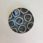 Island ripple mamezara: a small round plate with pale outlined circles floating over a deep indigo speckled glaze